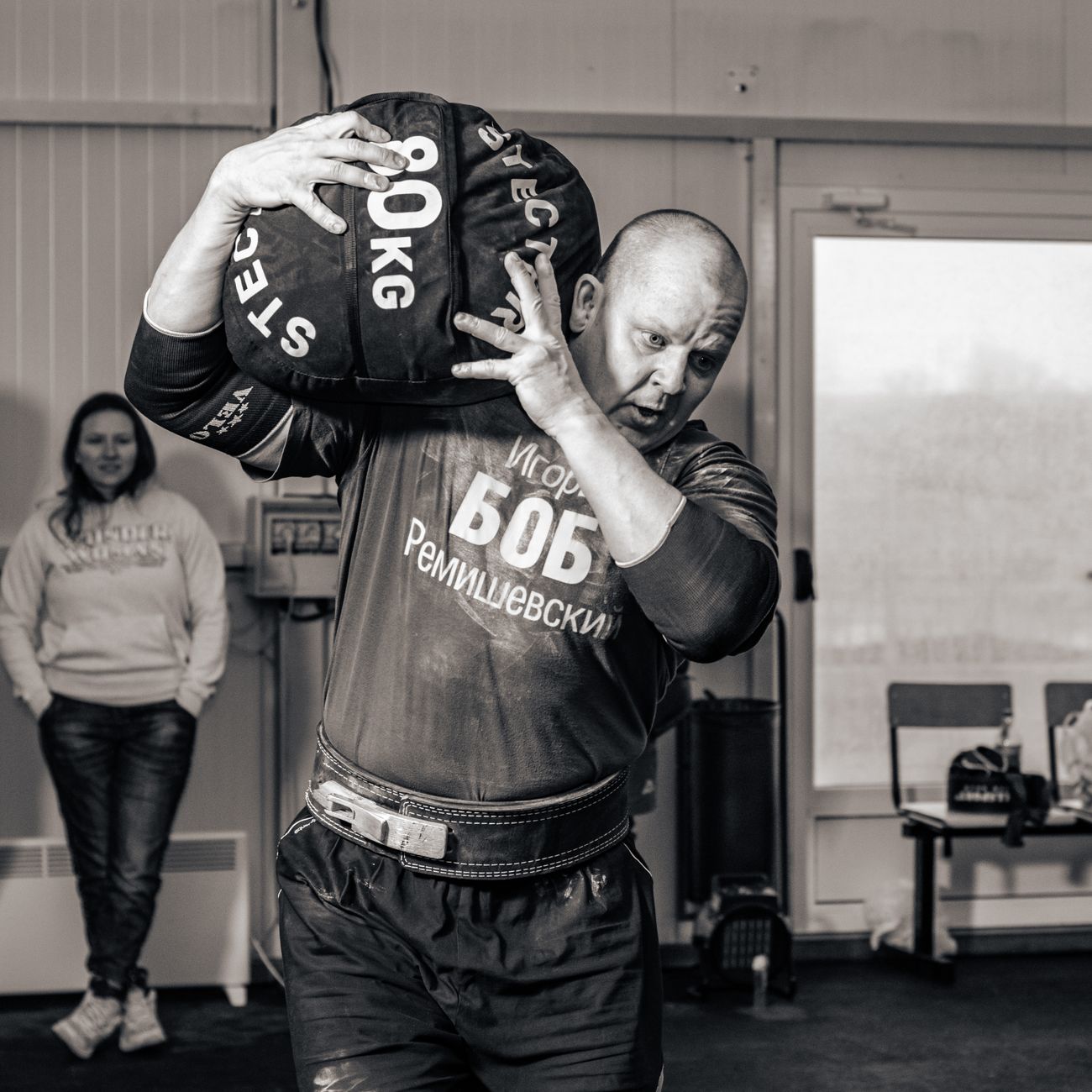 sportsman carrying heavy bag training in gym