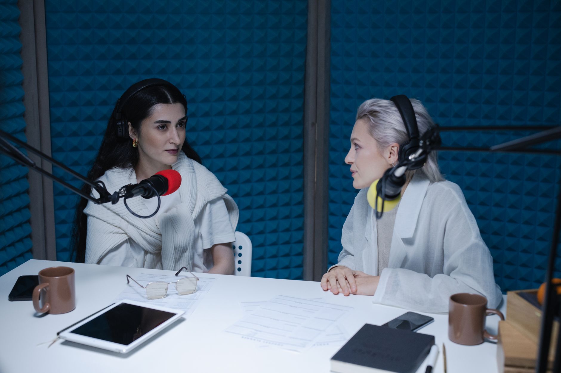women having conversation while wearing headphones