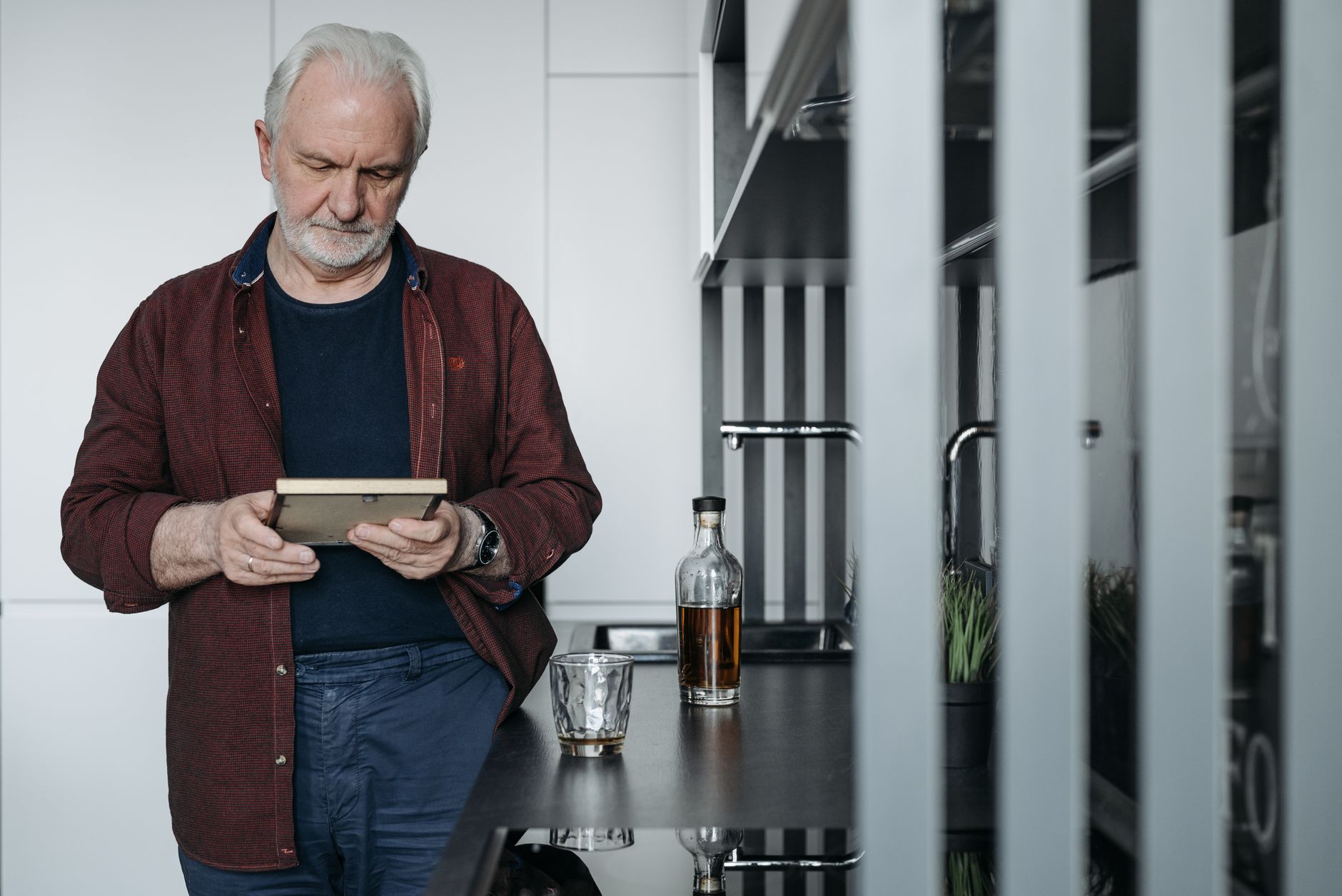 a man with gray hair holding a picture frame