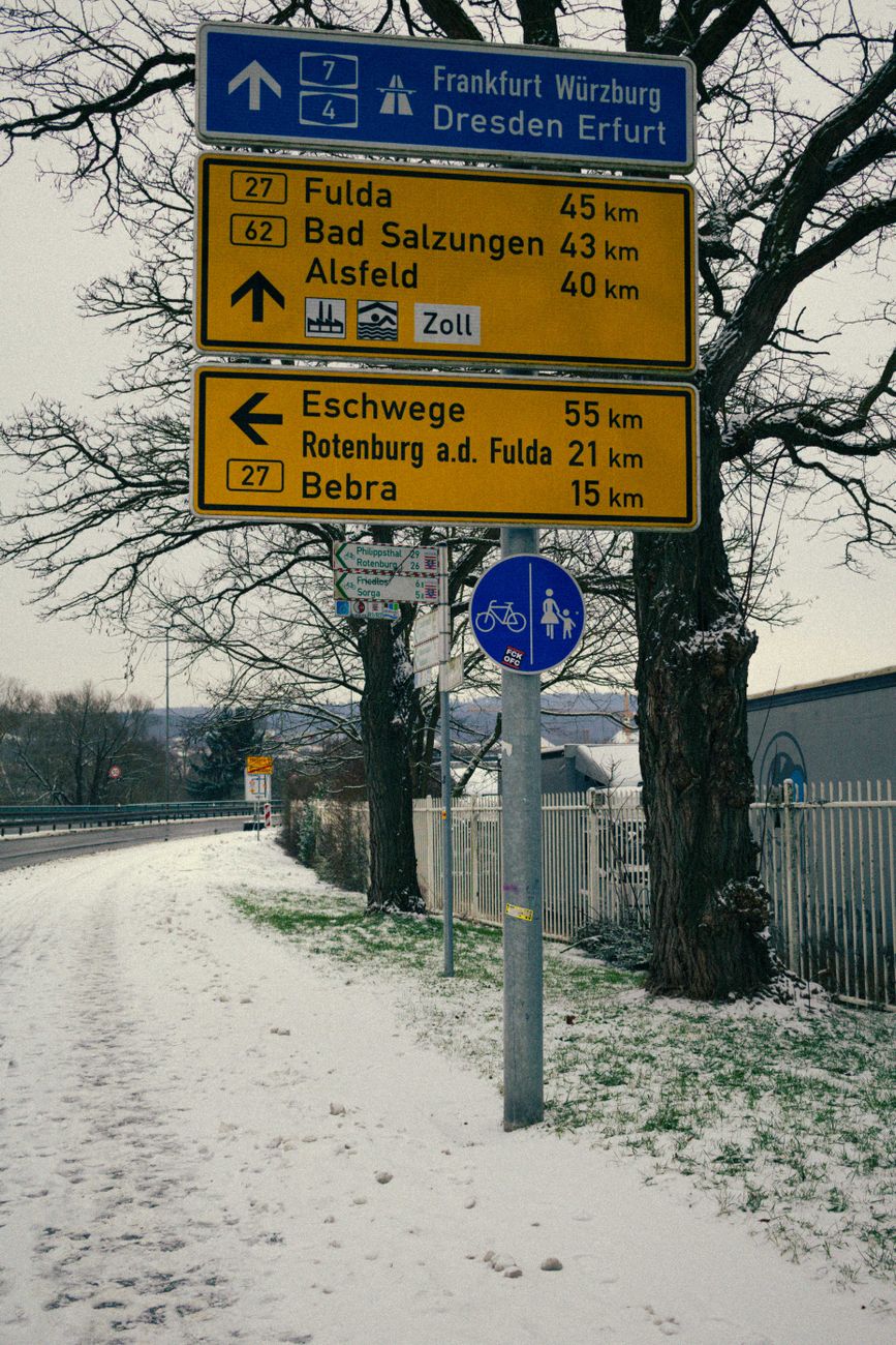 snowy road with directional signs in winter