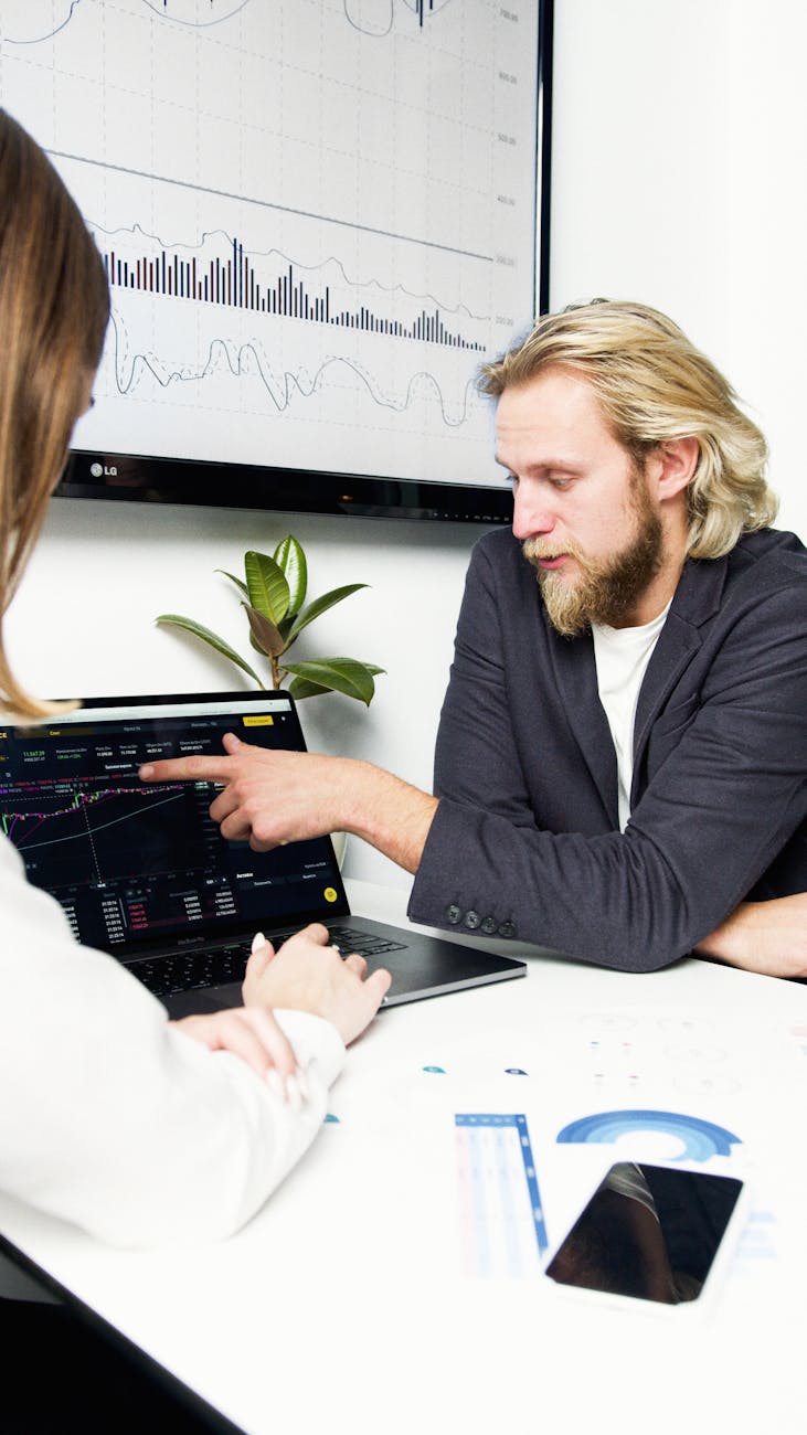 man in black suit jacket sitting beside woman in white long sleeve shirt