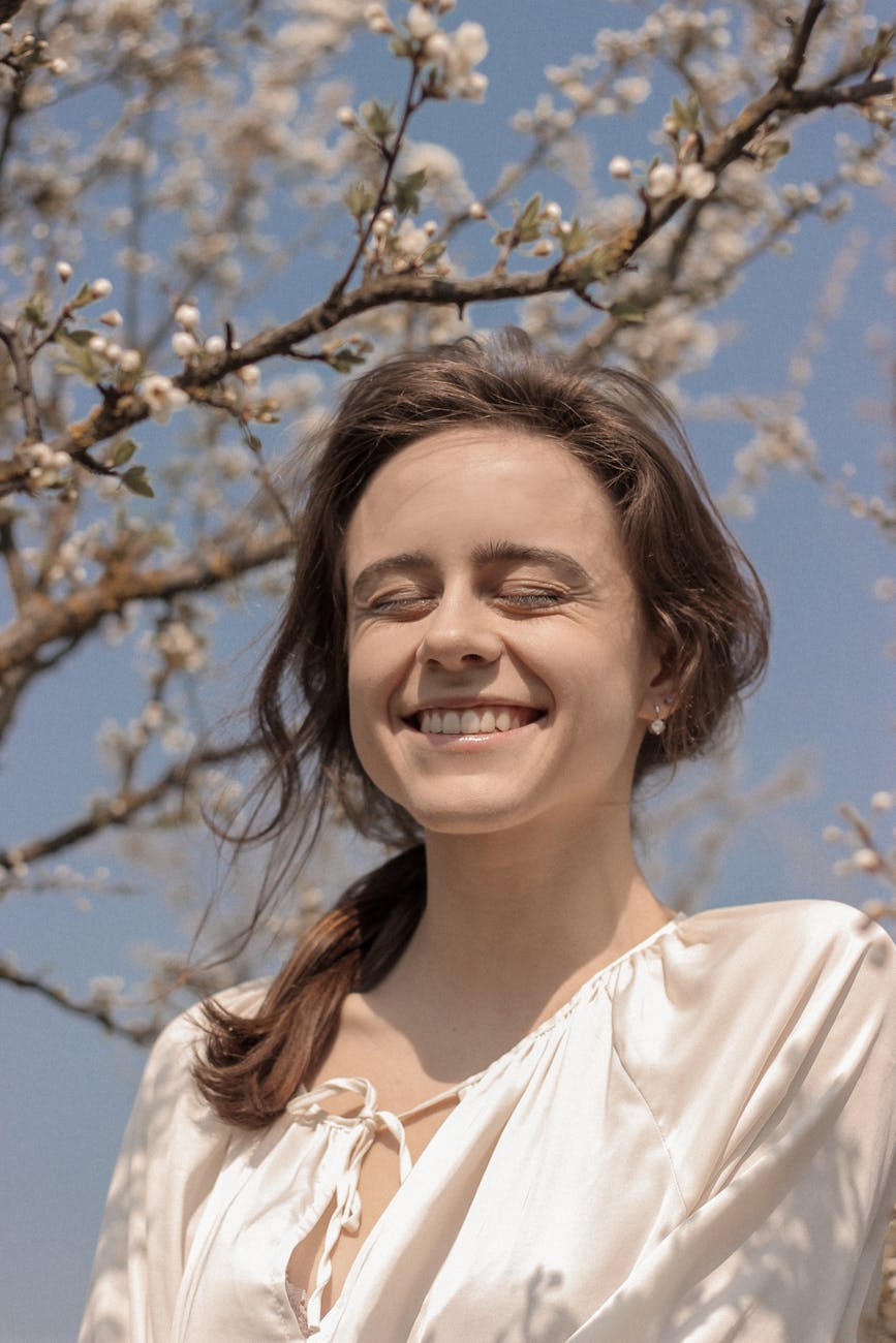 smiling woman in white top under blue sky